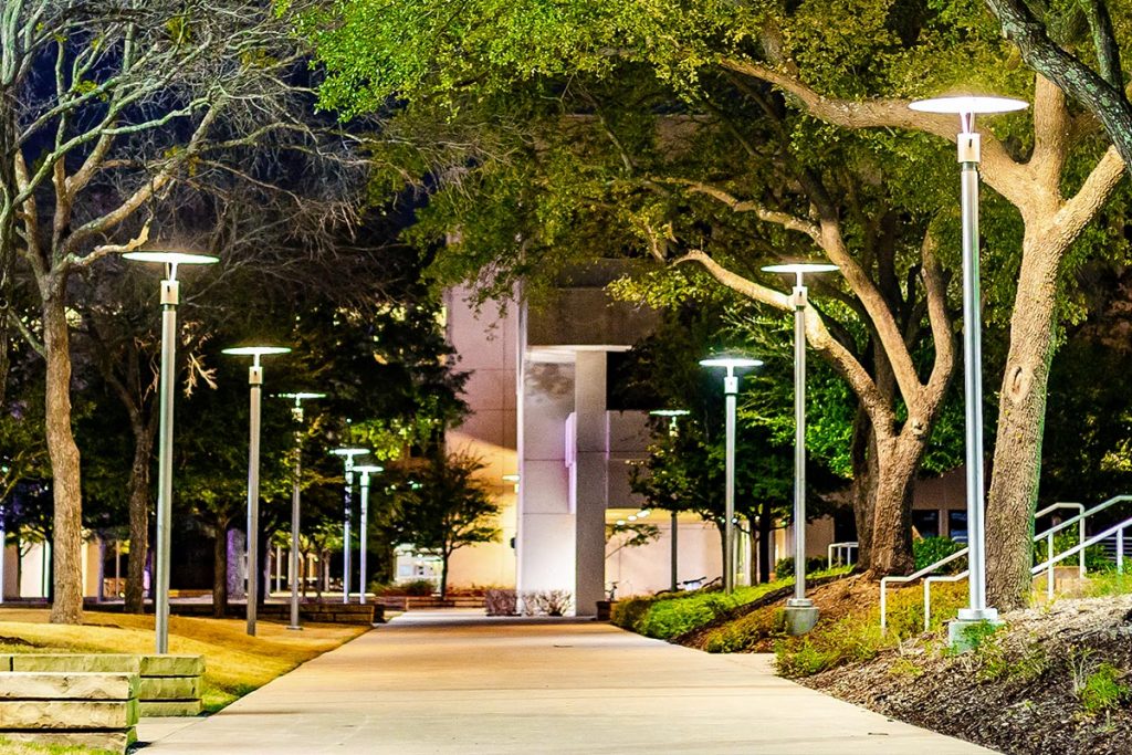 A campus walkway at night.