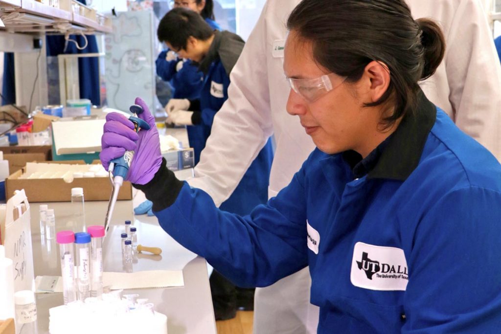 A researcher uses a liquid dropper in a laboratory. 