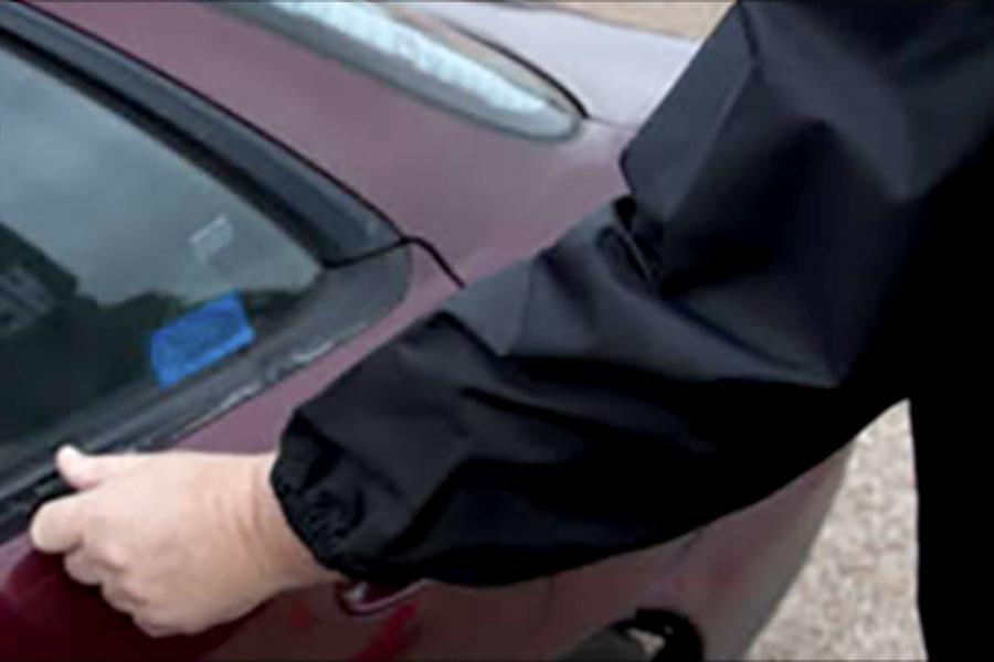 A person etches a VIN number onto a vehicle.