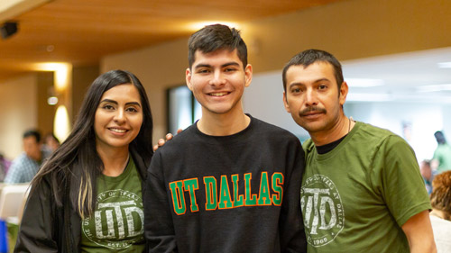 A student and his parents wearing UTD T-shirts.