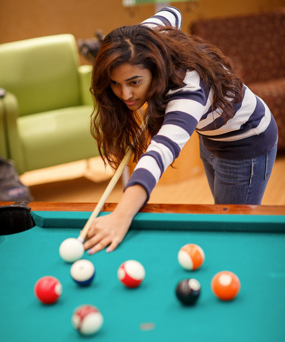 a student playing billiards