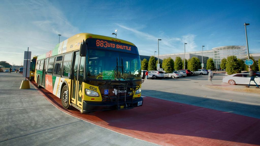 An 883 UTD-DART bus pulls up outside the Visitor Center. 